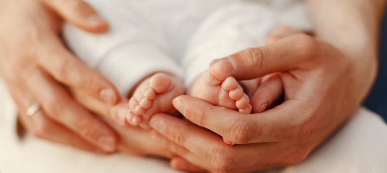 Hände umschliessen Babyfuesschen