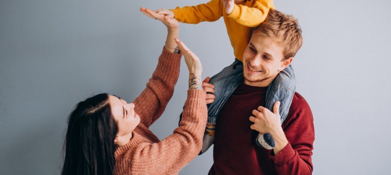 Junge Familie mit kleinem Sohn auf grauem Hintergrund